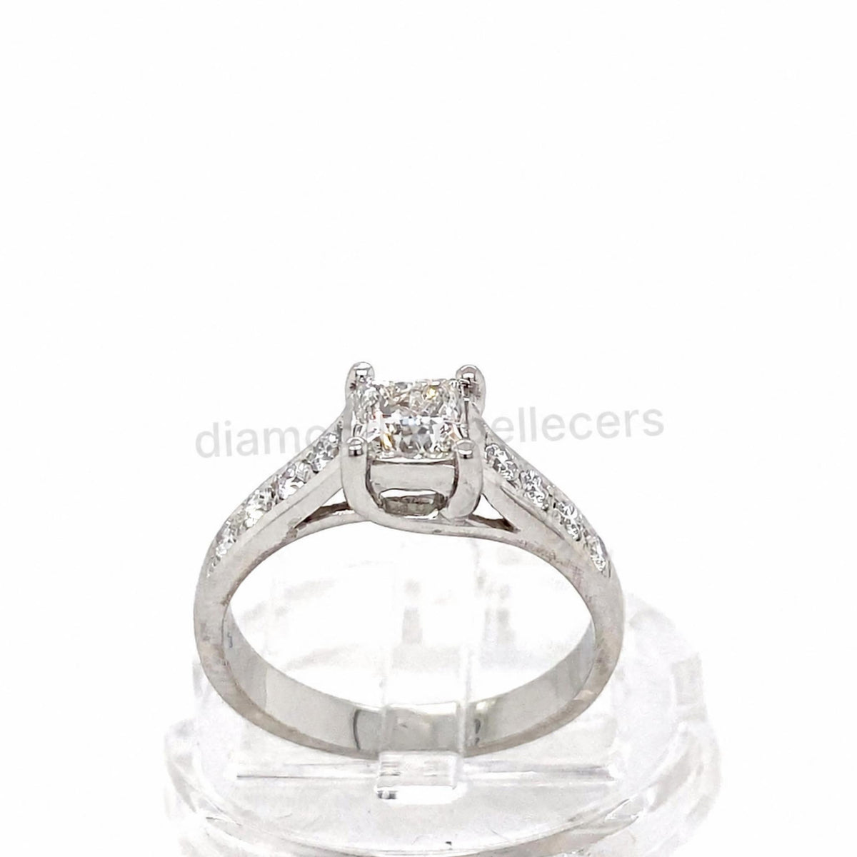 A platinum diamond ring with a square princess-cut centre stone and pavé-set side stones round brilliant diamond .