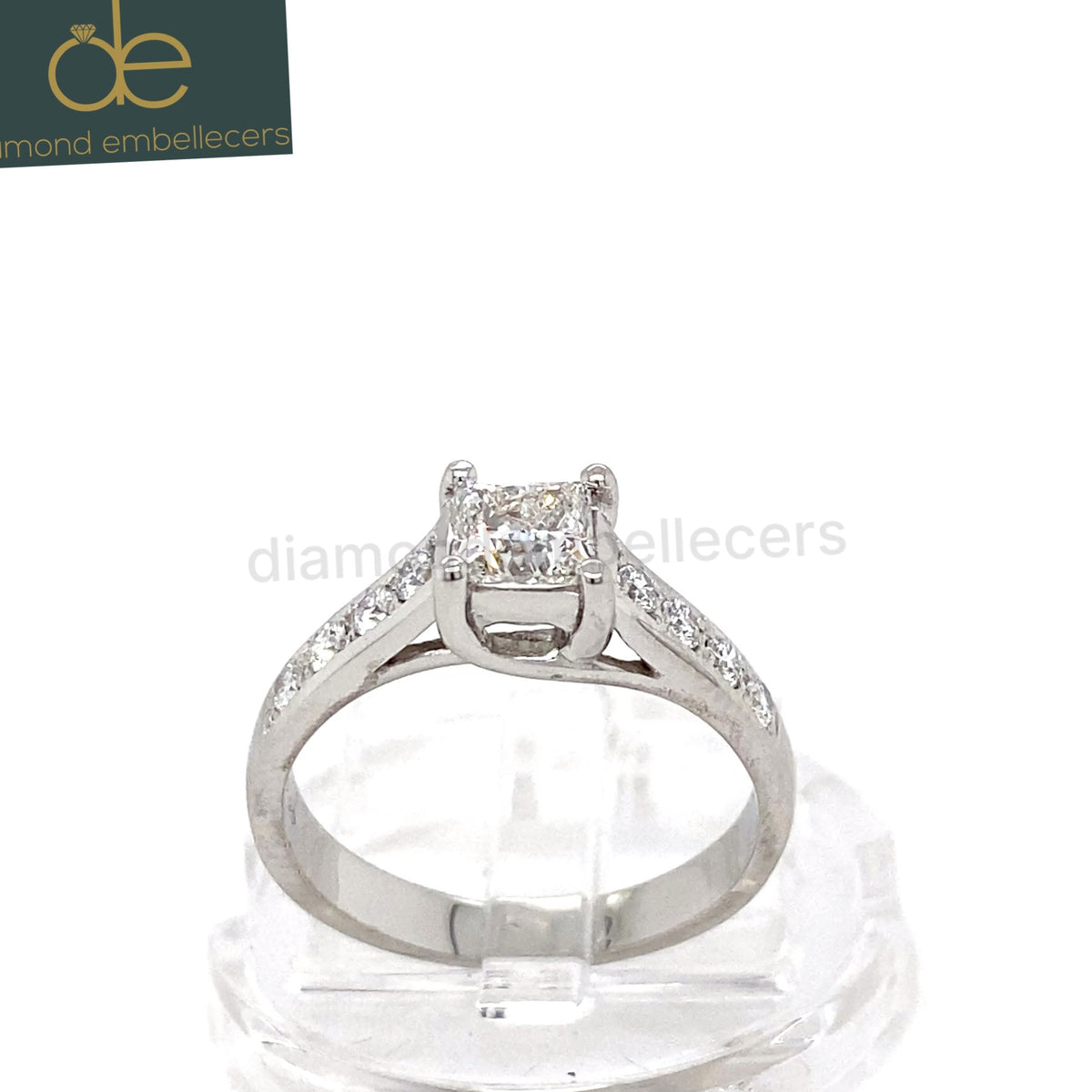 A platinum diamond ring with a square princess-cut centre stone and pavé-set side stones round brilliant diamond .