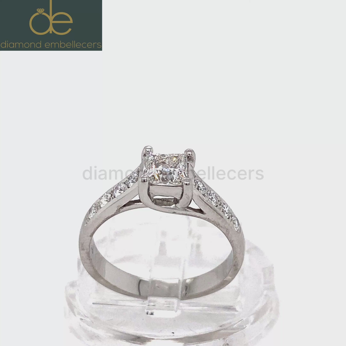 A platinum diamond ring with a square princess-cut centre stone and pavé-set side stones round brilliant diamond .